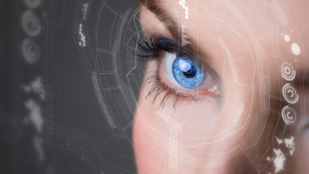 close up view of a person's blue eye with semi-transparent pieces of code and graphics around it